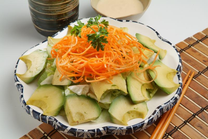 Avocado and lettuce garnished with carrot strands and parsley on top